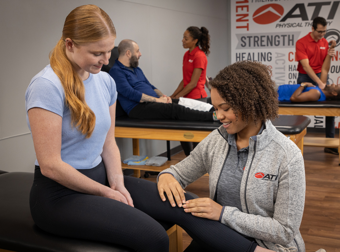 ATI therapist assisting a patient with knee pain