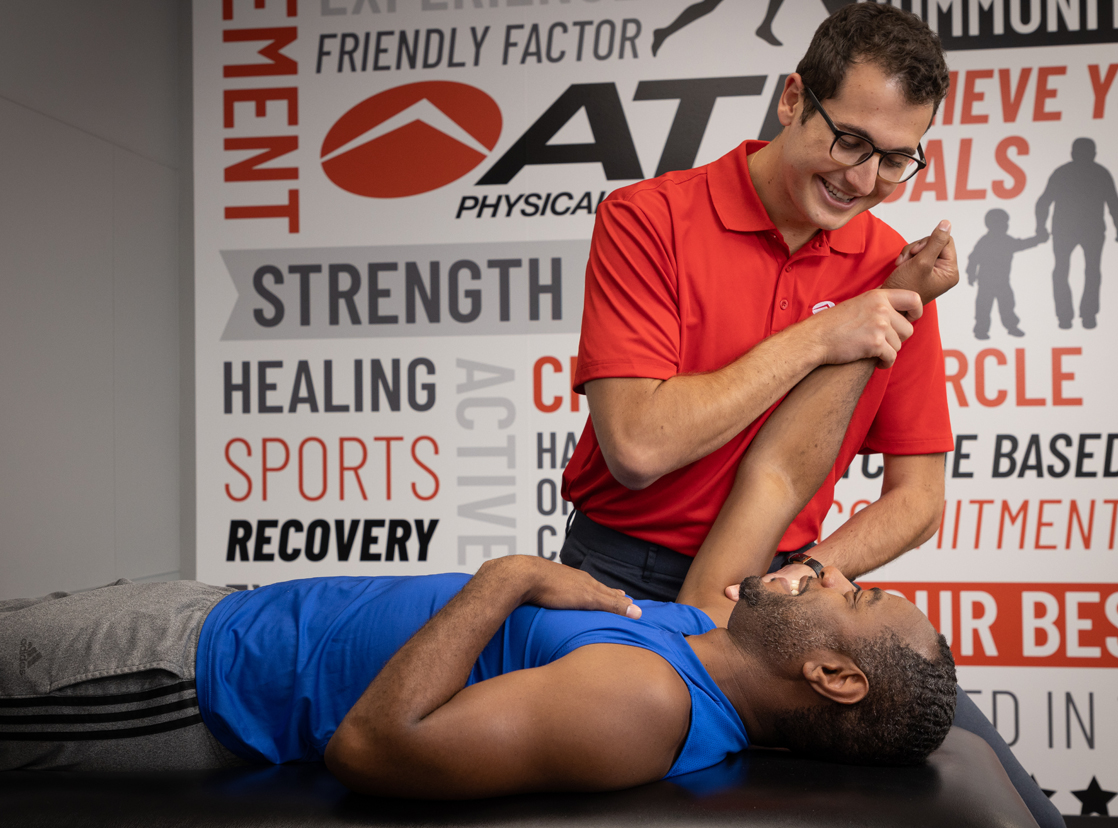 ATI therapist assisting a patient with shoulder pain