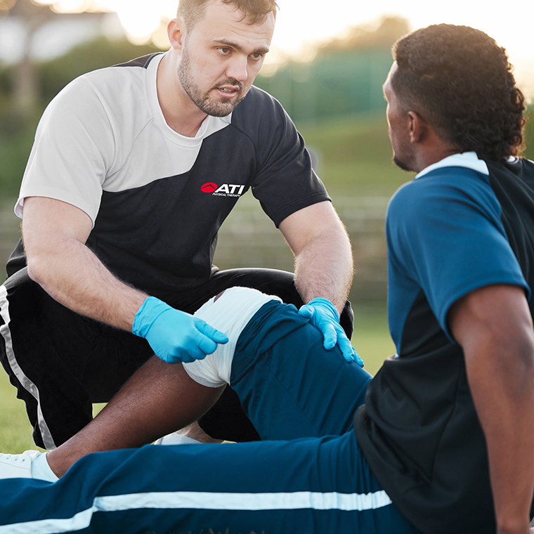 ATI Athletic trainer helping an athlete