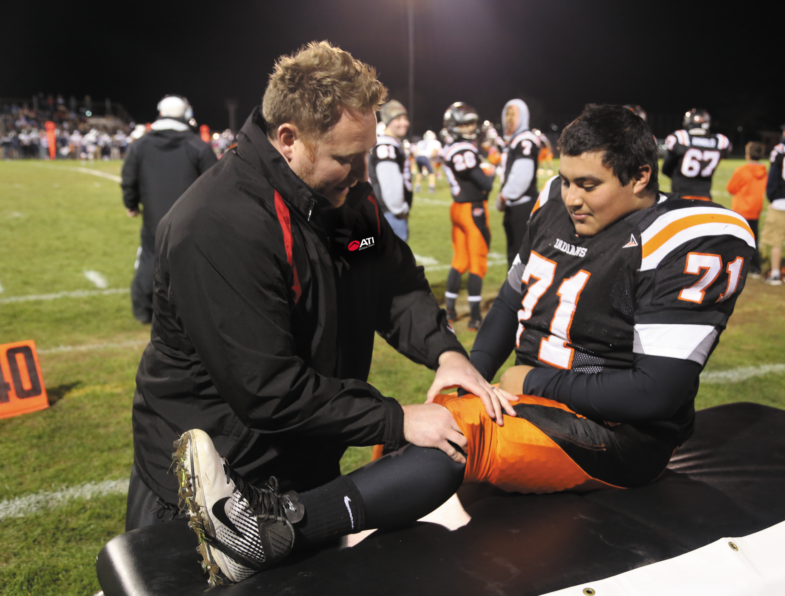 PT helping an injured football player